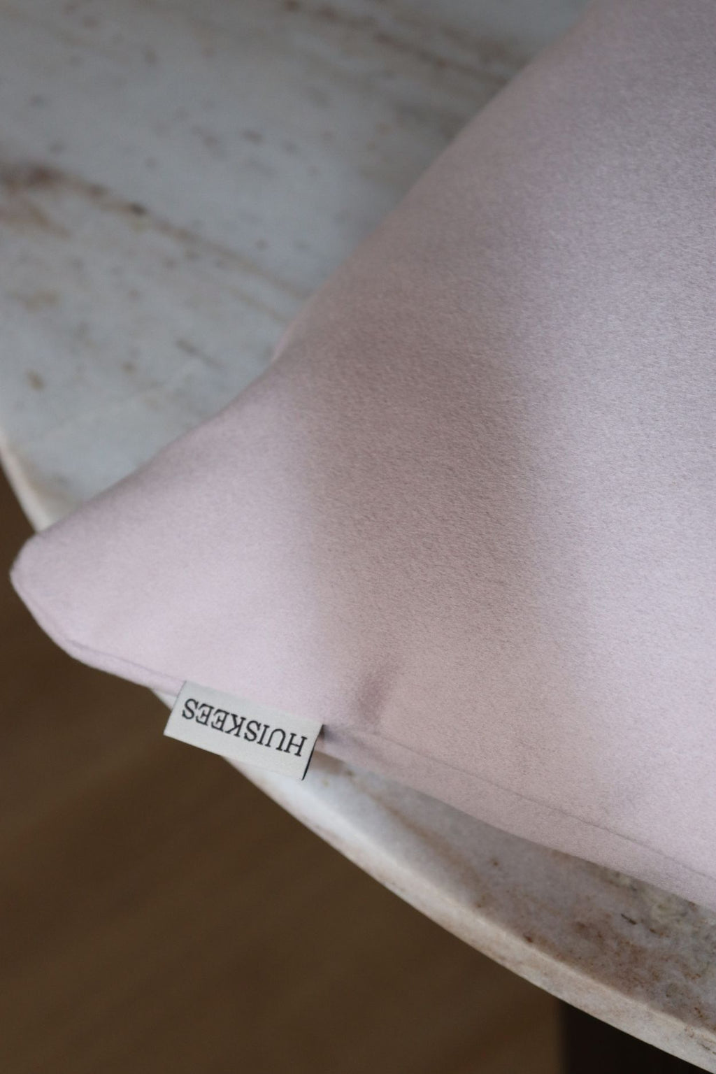 Een close up van een lichtroze sierkussen.