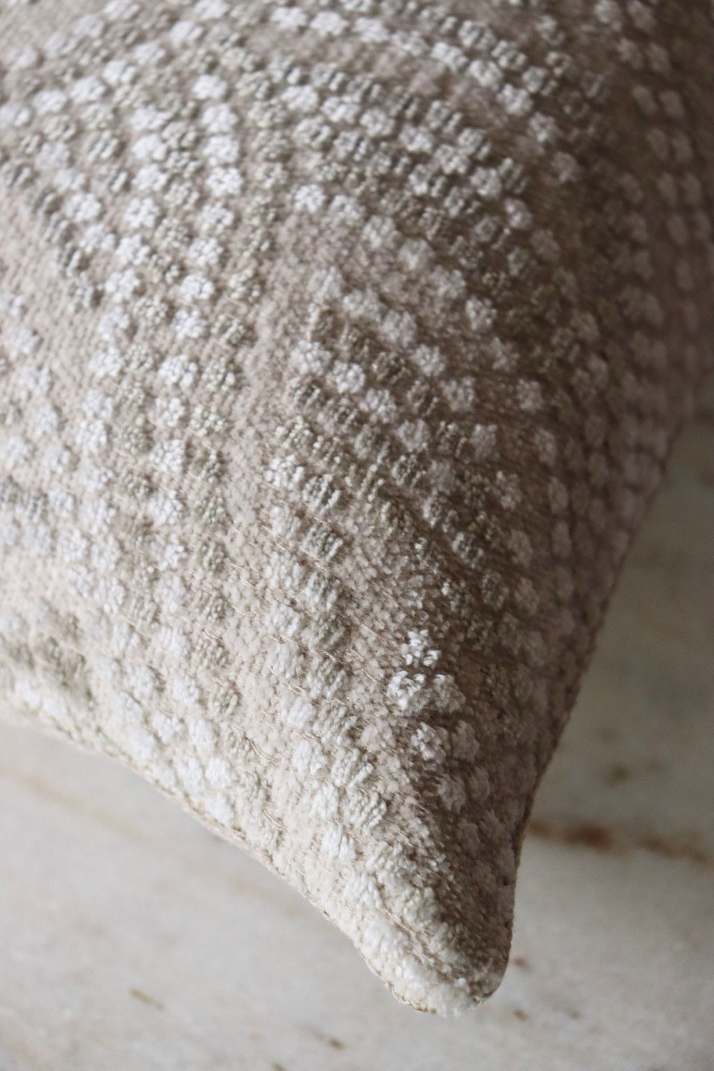 De stof van een grijswitte sierkussen.