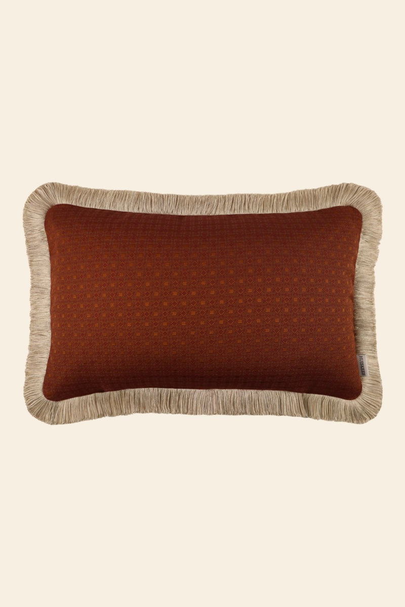 Oranje sierkussen met beige franjes in een rechthoekig formaat.