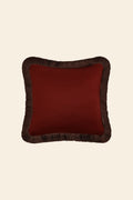 De voorkant van een donkerrood sierkussen in een vierkant formaat met donkerbruine franjes.