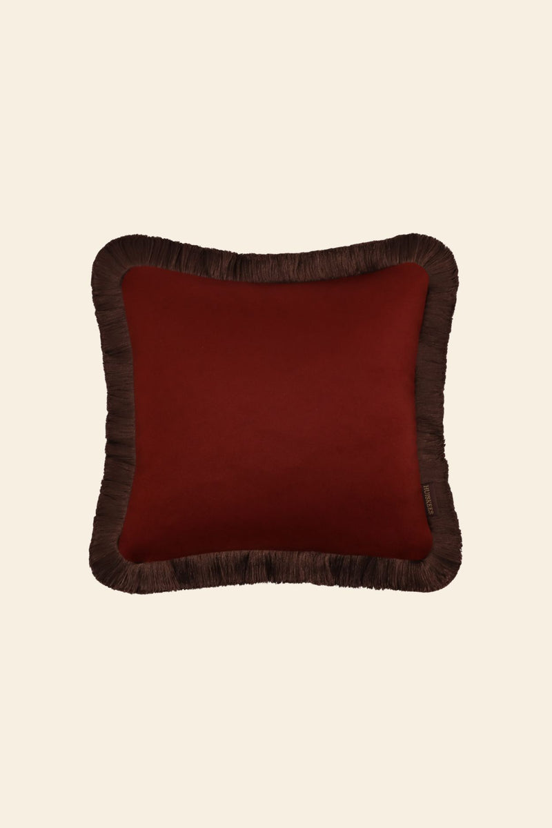 De voorkant van een donkerrood sierkussen in een vierkant formaat met donkerbruine franjes.