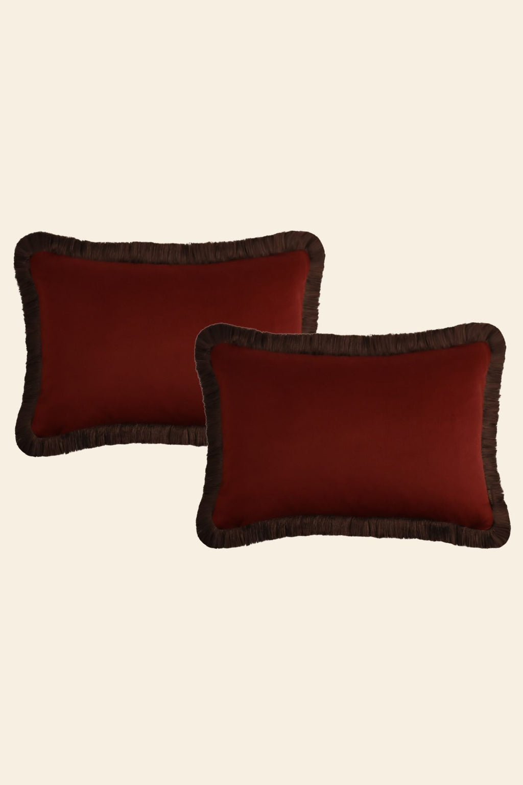 Een set van twee grote rode sierkussens met franjes.