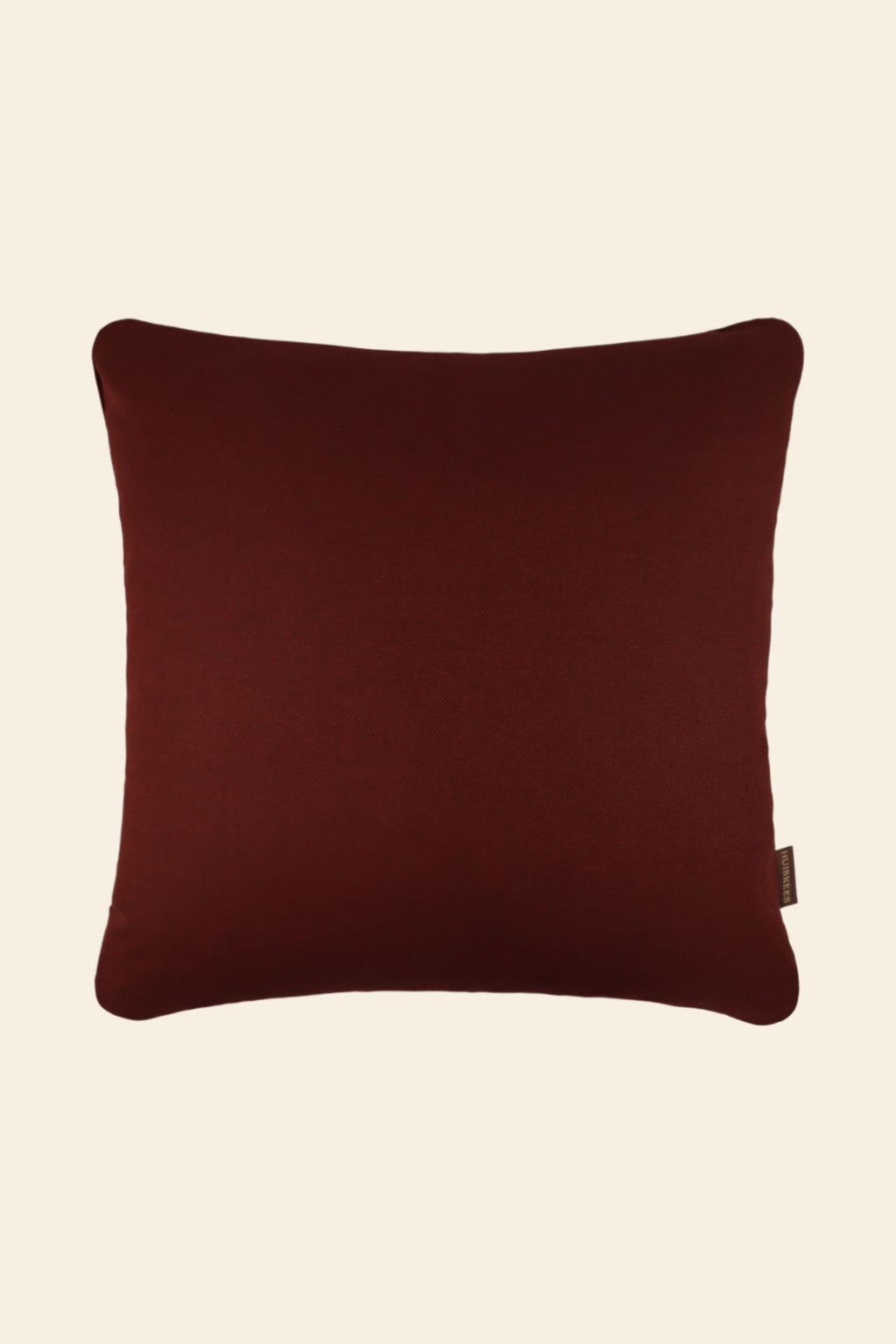 De voorkant van een bordeauxrood sierkussen.
