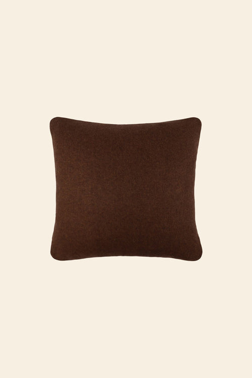 De voorkant van een bruin sierkussen in een vierkant formaat.