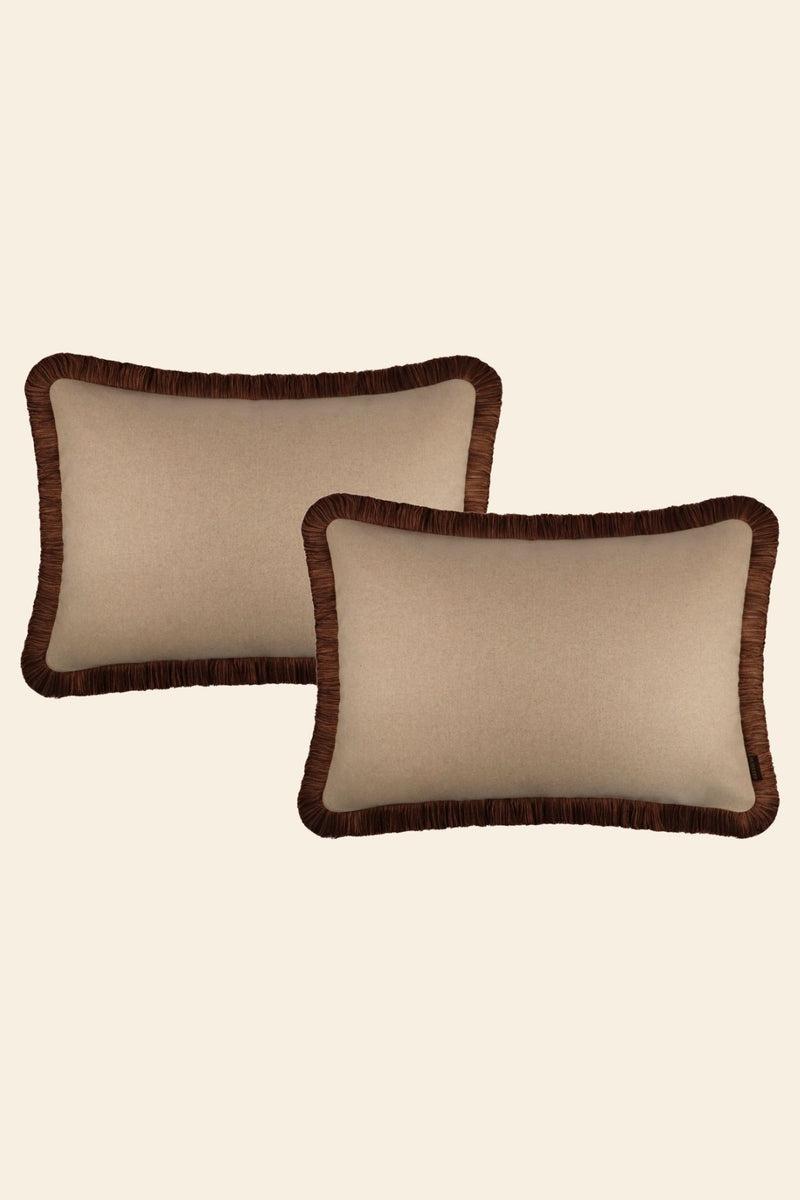 Twee beige sierkussens met bruine franjes.
