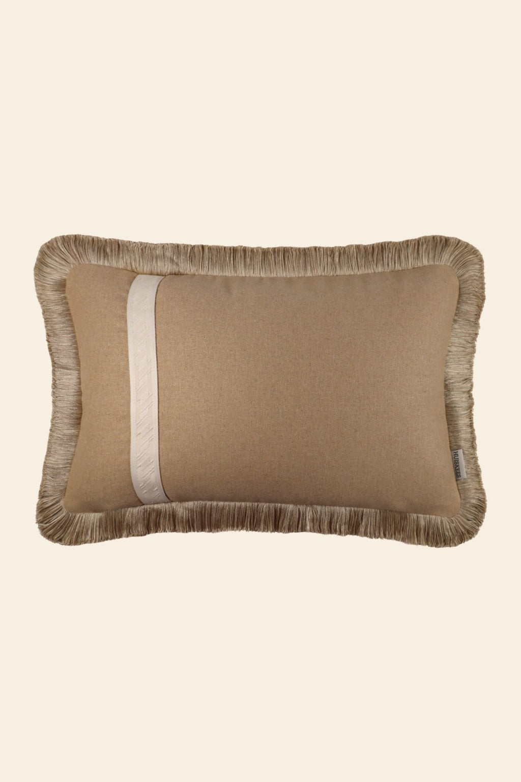 De voorkant van een wollen sierkussen met band en franjes.