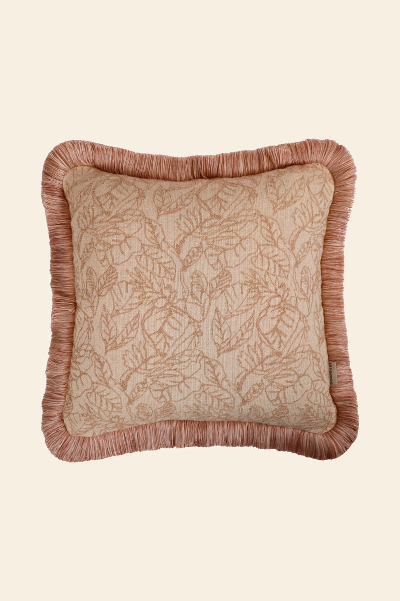 Vooraanzicht van een kussen met lichtroze bladerenmotief en roze franjes.
