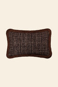 De voorkant van een bruin sierkussen met luxe ruitmotief en bruine franjes.