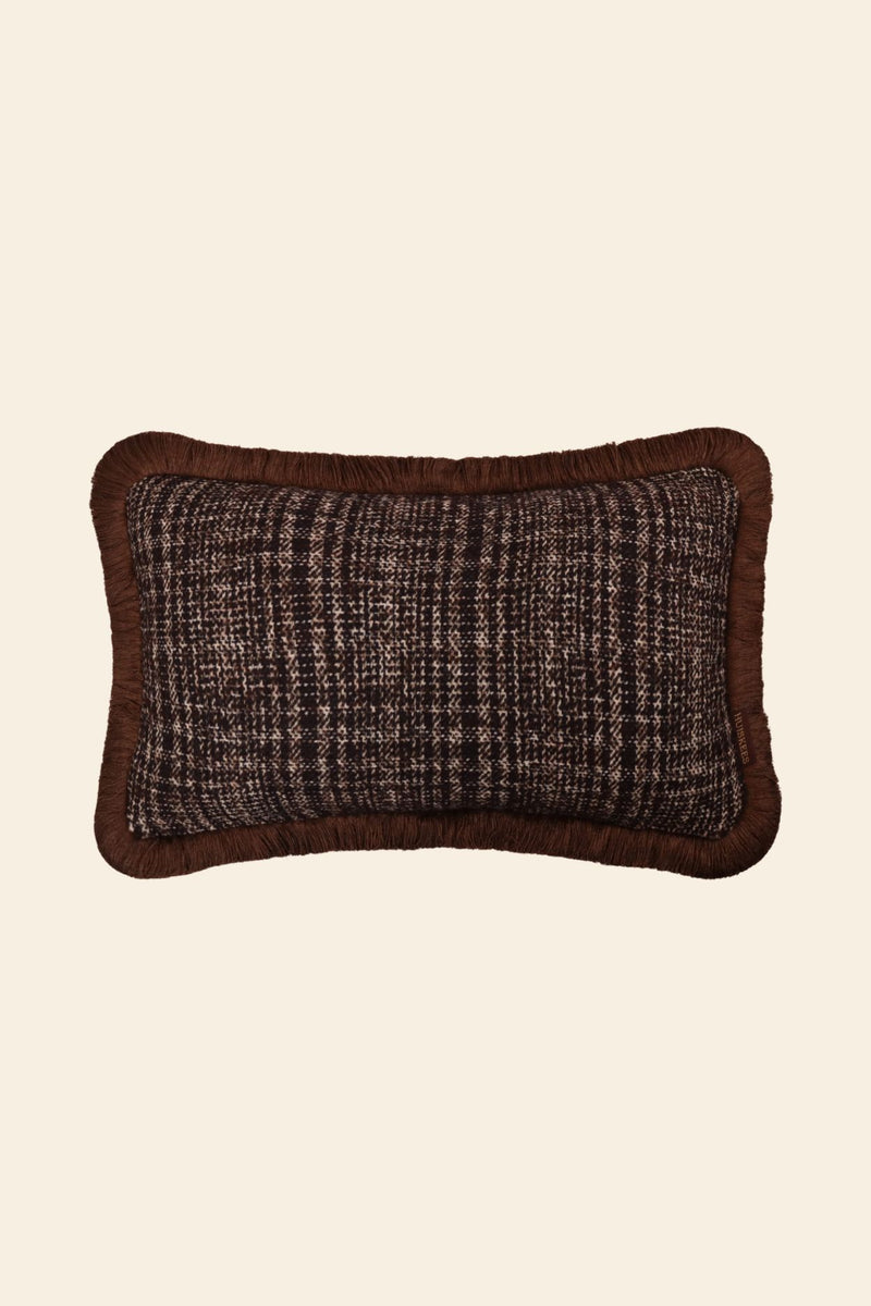 De voorkant van een bruin sierkussen met luxe ruitmotief en bruine franjes.