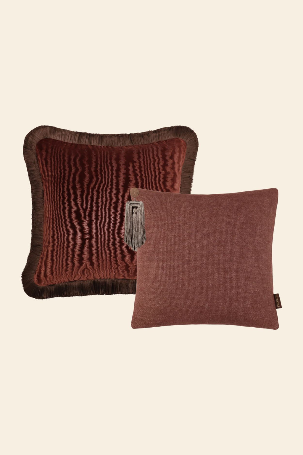 Een sierkussenset met 2 roze sierkussens met franjes en kwastjes.