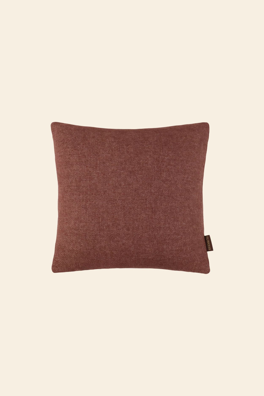 Een roze sierkussen in een vierkant formaat.