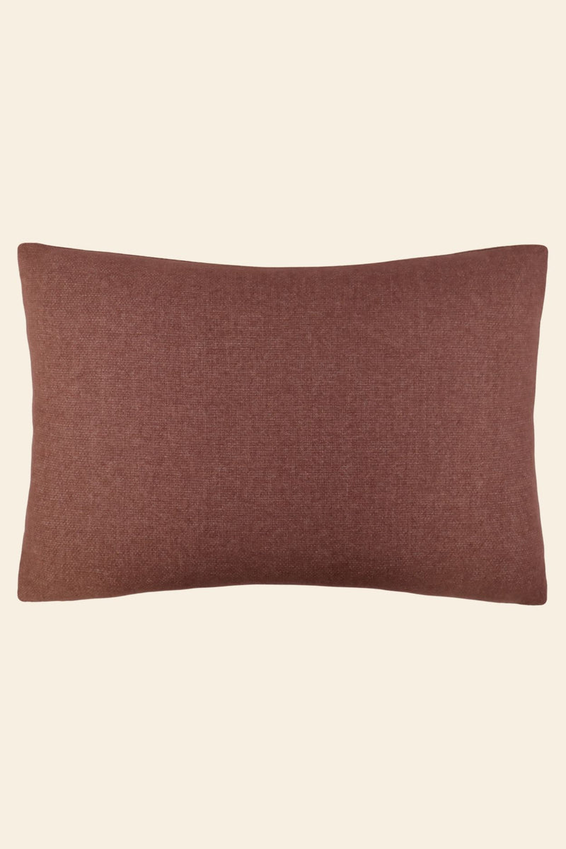 De voorkant van een roze wollen sierkussen in een extra groot formaat.