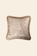 De voorkant van een luxe beige sierkussen met beige franjes.