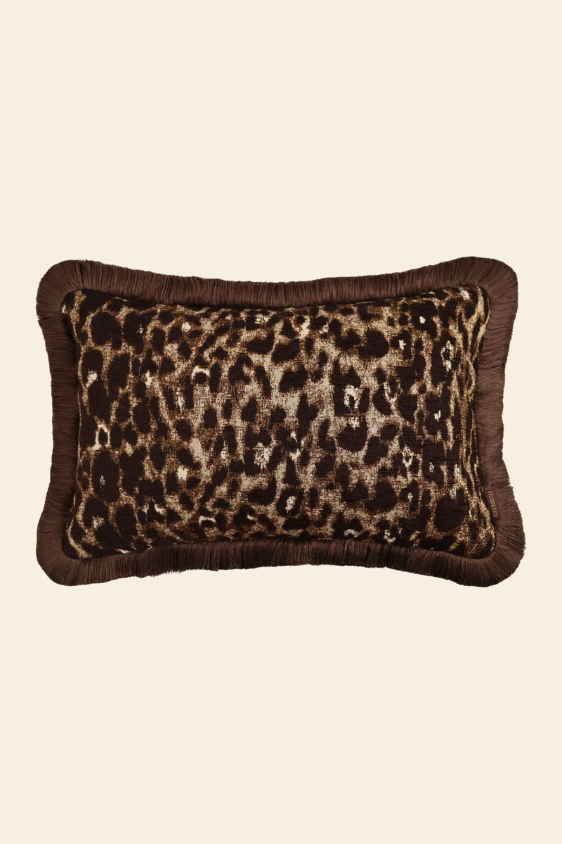 De voorkant van een bruin sierkussen met luipaardmotief en bruine franjes.