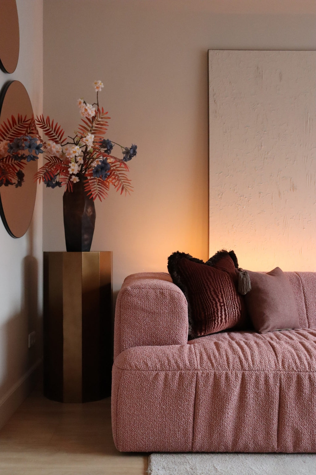 Twee roze sierkussens op een roze bank.